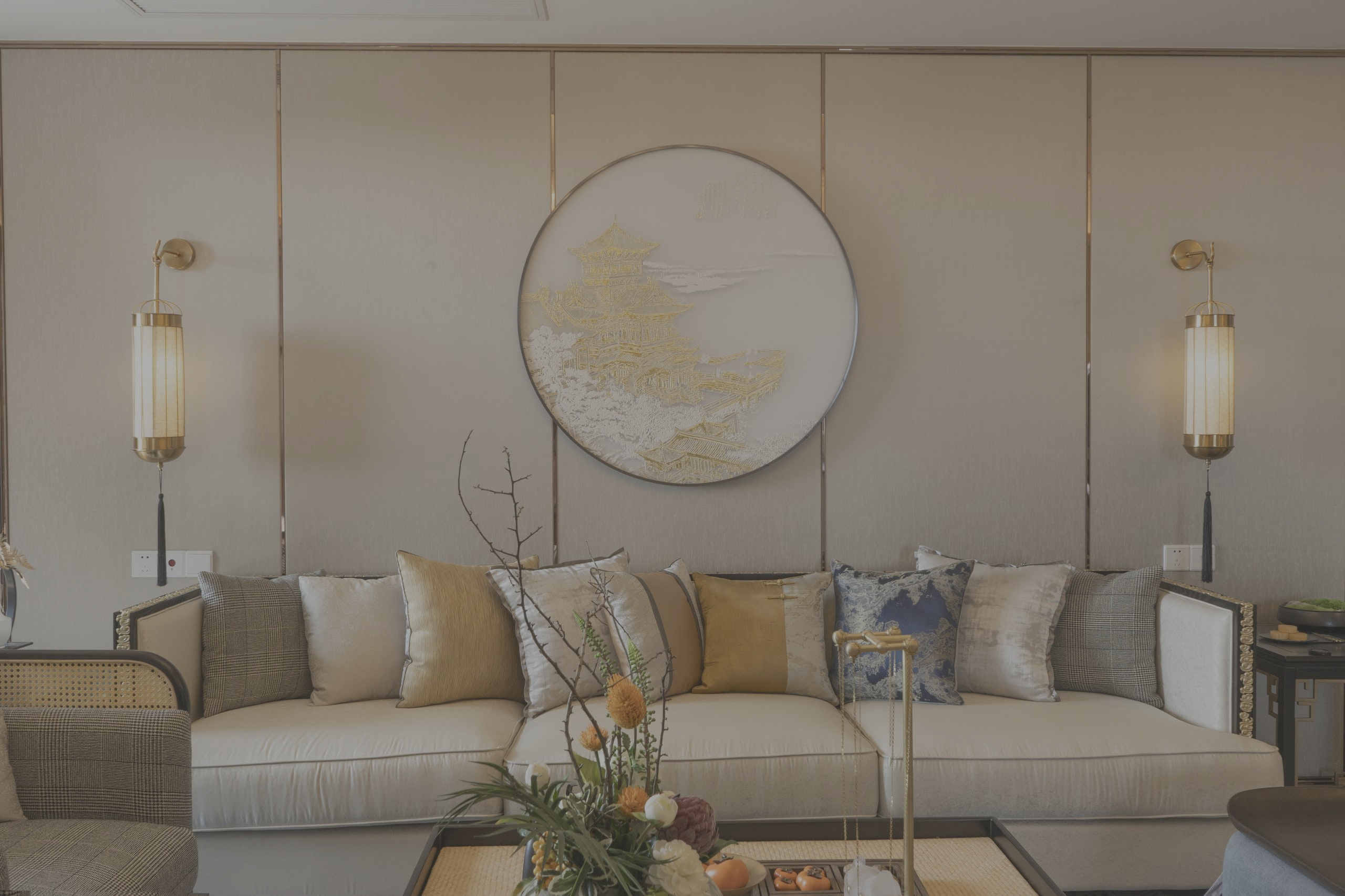 Elegant living room with a long cream sofa, gold accents, and a circular wall artwork above