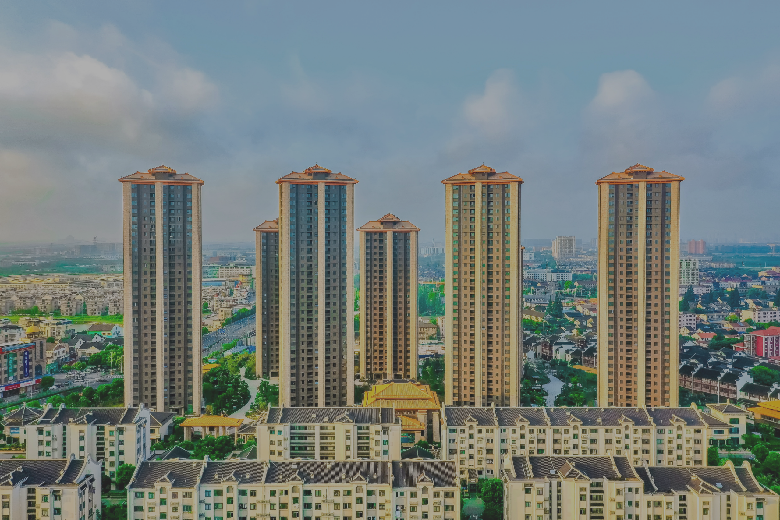 Elegant living room with a long cream sofa, gold accents, and a circular wall artwork above