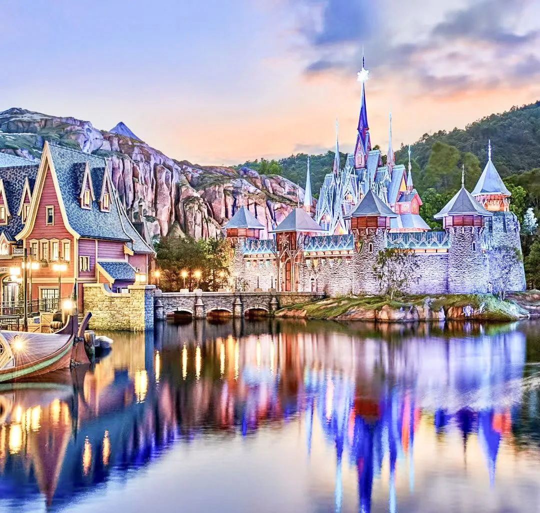 Colorful fantasy castle with detailed decorative coatings, textured walls, and ornamental architecture reflected on a lake at sunset